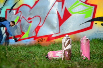 A few used paint cans against the background of the space with the wall on which the young guy...