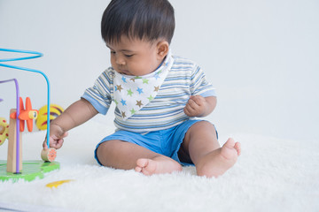 Cute little asian baby sitting play toy