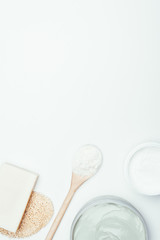 flat lay with soap, sponge, spoon, clay masks in containers and clay powder isolated on white surface