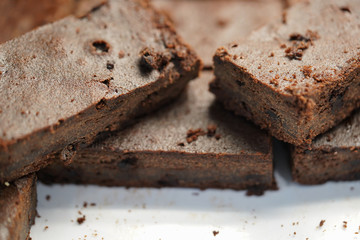 Homemade Chocolate brownies on white disc.