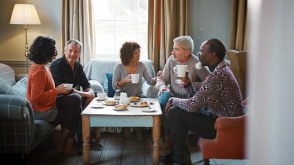 Group Of Middle Aged Friends Meeting Around Table In Coffee Shop - Powered by Adobe