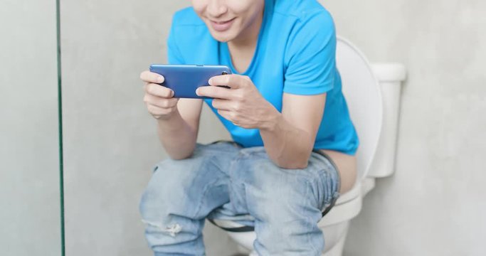man use phone on toilet
