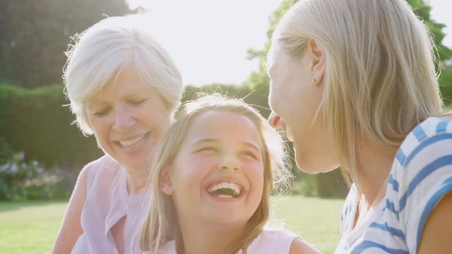 Three female generations of a family laughing in the garden
