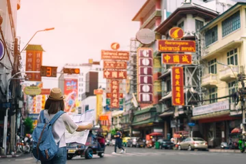 Fotobehang Bangkok Jonge Aziatische vrouw reiziger met blauwe rugzak en hipster hoed op zoek kaart op weg met tuk tuk Thailand achtergrond in China Town Bangkok. Reizen in Bangkok Thailand