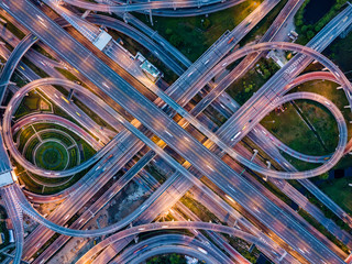 Top view of Highway road junctions at night. The Intersecting freeway road overpass the eastern...