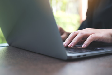 Closeup image of hands working and typing on laptop keyboard in office