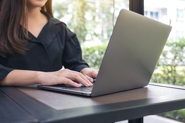 Closeup image of a business woman working and typing on laptop keyboard in office