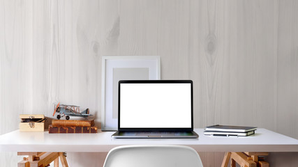 Loft workspace with blank screen laptop and mockup poster on white desk.