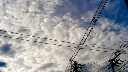 cables under the sky with clouds
