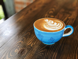 Morning Coffee cup,latte art coffee cup on the wooden  background with vintage cafe light. Copy space and vintage style