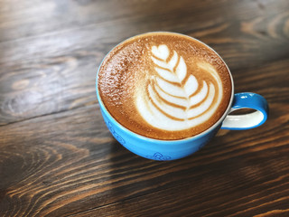 Morning Coffee cup,latte art coffee cup on the wooden  background with vintage cafe light. Copy space and vintage style