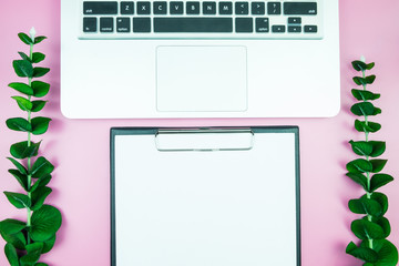 Women's stylish table. Workspace with blank white paper free space and pen in desk with flowers on pink pastel background for magazines, websites, media, Instagram. Flat lay, top view.