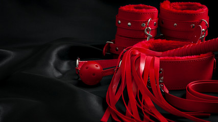 Bondage, kinky adult sex games, kink and BDSM lifestyle concept with a pair of red leather...