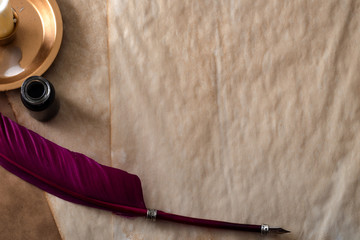 Writing a book and vintage letter concept with top view of a candle, old quill pen and ink bottle or inkwell on blank aged parchment paper with copy space © Victor Moussa
