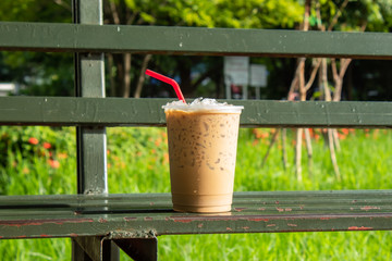 Coffee cool moment the sun is low. On a steel chair in the park