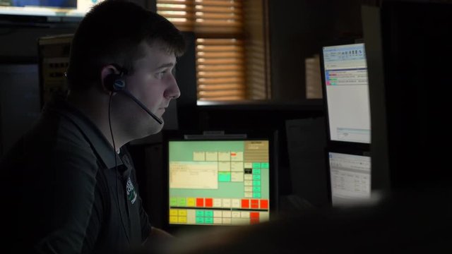 A 911 dispatcher works at his computer station at a control center to help respond to emergency calls.