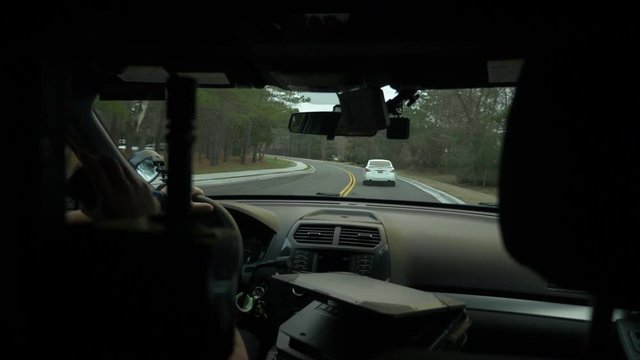 Police officer driving his patrol car to enforce traffic laws.