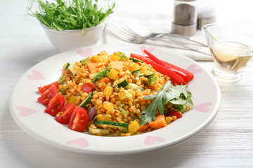 Plate with delicious lentils salad on wooden table