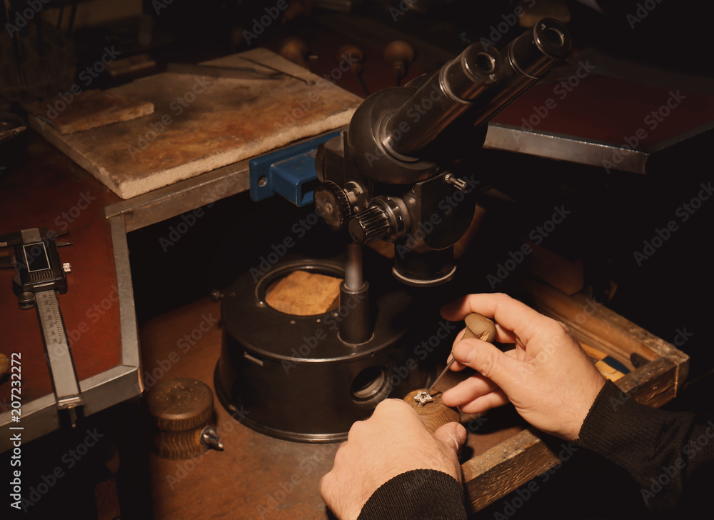 Wall mural jeweler working on ring, closeup