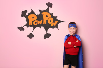 Cute boy in superhero costume on color background - Powered by Adobe