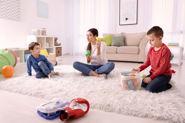 Nanny and two little boys playing at home
