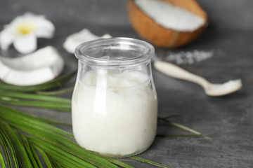 Obraz na płótnie Canvas Glass jar with coconut oil on table. Healthy cooking