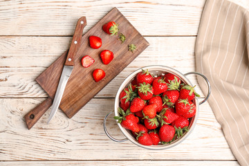 Flat lay composition with ripe red strawberries on wooden background