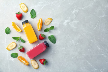 Flat lay composition with tasty juices and ingredients on light background