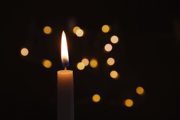 Wax candle burning on blurred background, closeup