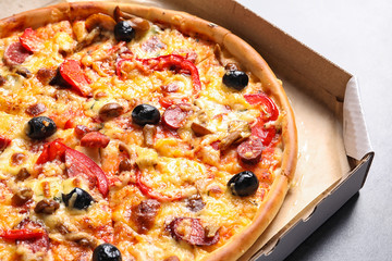 Cardboard box with delicious pizza, closeup