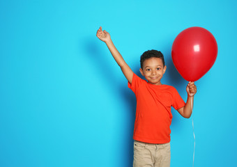 Cute African-American boy with balloon on color background. Birthday celebration © New Africa