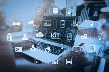 business documents on office table with smart phone and laptop computer and graph business with social network diagram and three colleagues discussing data in the background