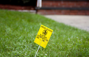 Yellow Pesticide Application Warning On Green Lawn