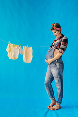 Pregnant girl on blue background in pin-up style