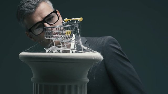 Business executive and dusty miniature shopping cart