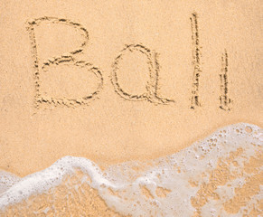 The word Bali written in the sand on beach