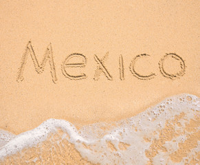 The word Mexico written in the sand on beach