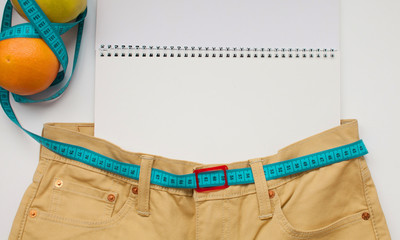 slimming for new jeans. jeans with meter belt slimming. measuring waist. Healthy lifestyle and...
