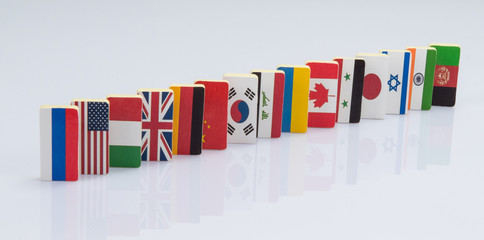 Fototapeta premium The domino effect with tiles of flags of different countries of the world. conceptual photo, political games. Studio shooting