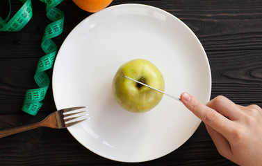 Losing weight. Strict diet. Empty plate and measuring tape instead food on wooden background top view mockup.