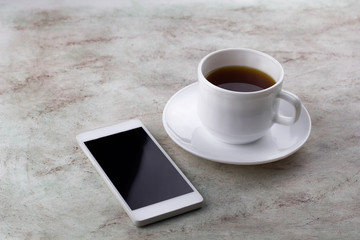 Fototapeta na wymiar coffee cup and smartphone marble background