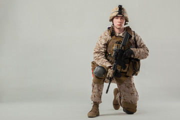 Soldier in camouflage holding rifle