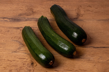 Fresh zucchinis on a wooden background