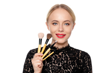 Beauty portrait of a smiling beautiful half naked woman posing with make-up brushes