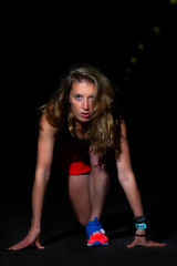 Fototapeta na wymiar Athlete girl in starting position for running