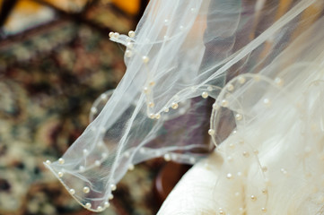 The wedding veil, decorated with beads. Light transparent cloth.