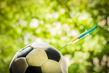 Soccer ball gets an injection / Soccer ball gets an injection with a syringe, doping in sports. - obrazy, fototapety, plakaty