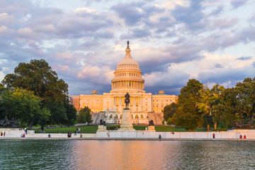 Obraz premium The United States Capitol building at sunset wirh reflection in water.