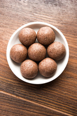 Nachni laddu or Ragi laddoo or balls made using  finger millet, sugar and ghee. It's a healthy food from India. Served in a bowl or plate over moody background. Selective focus