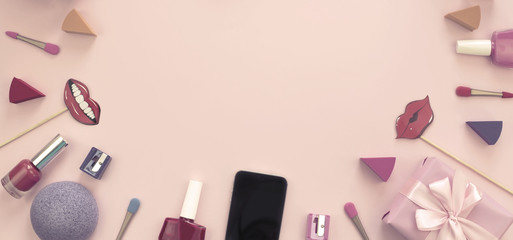 composition set of decorative cosmetics nail Polish lipstick sponge sharpener mobile phone box gift ribbon satin bow background pink.